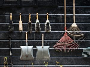 Neatly arranged garden tools hanging on a rustic wooden wall. — Eco-friendly Landscape Border