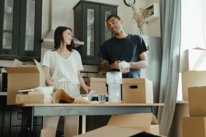 Smiling couple unpacking boxes in their new home kitchen, ready for a fresh start. — Those Rat 90-day Challenge - Organizing