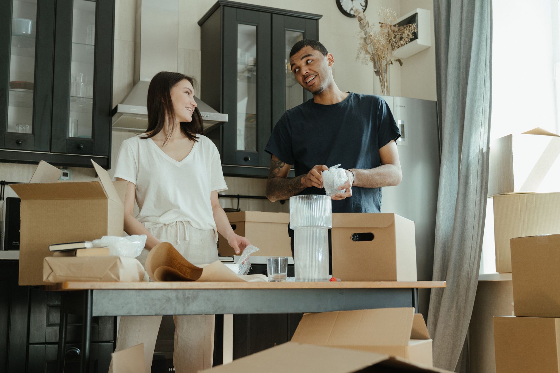 Smiling couple unpacking boxes in their new home kitchen, ready for a fresh start. — Those Rat 90-day Challenge - Organizing